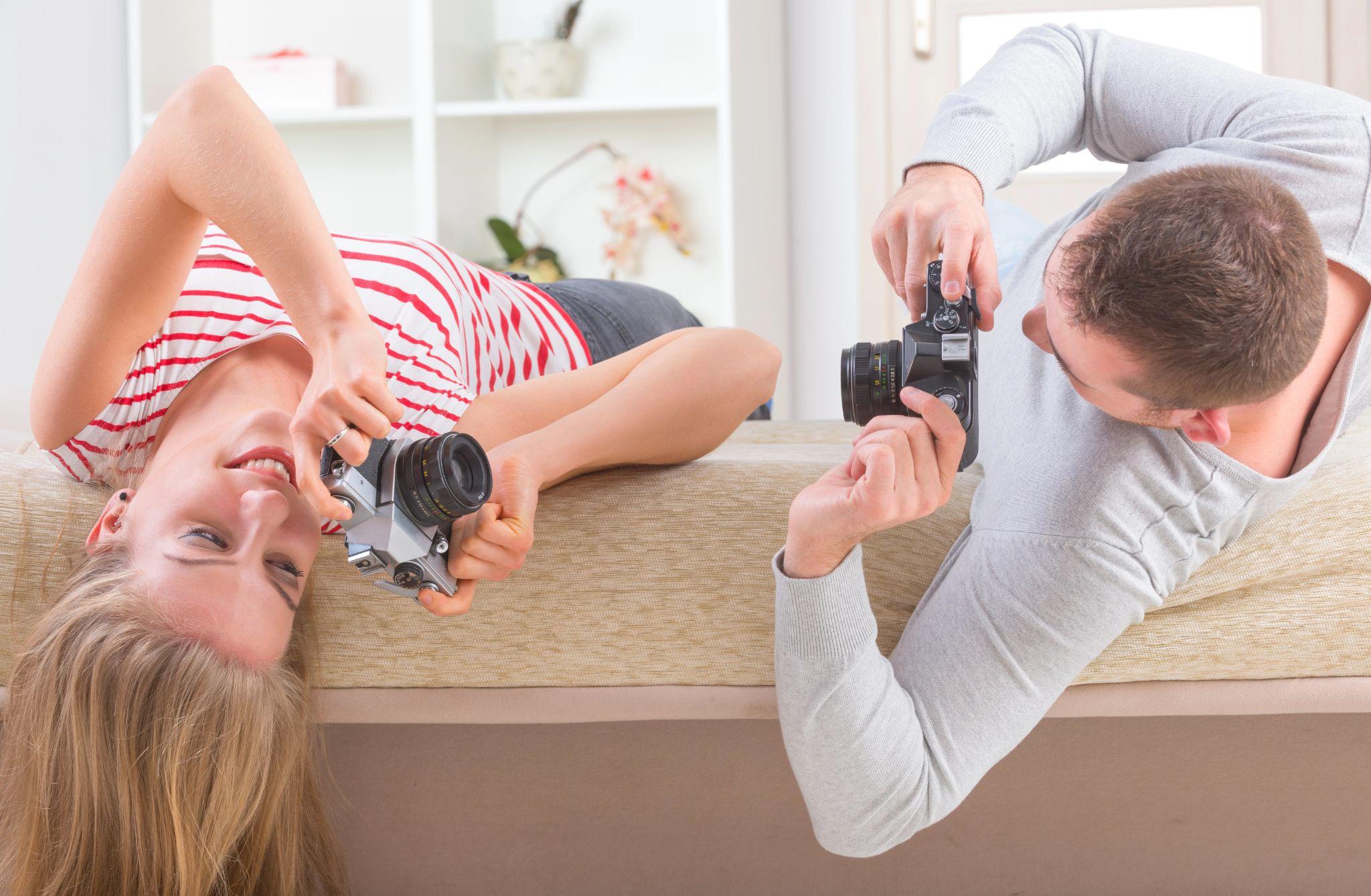 Couple taking pictures of each other at home