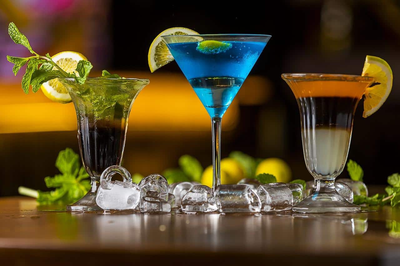 three cocktail glasses on wooden table