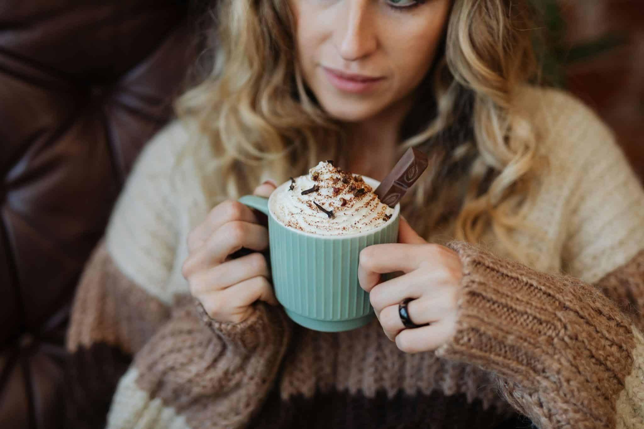 woman holding cup of hot cocoa