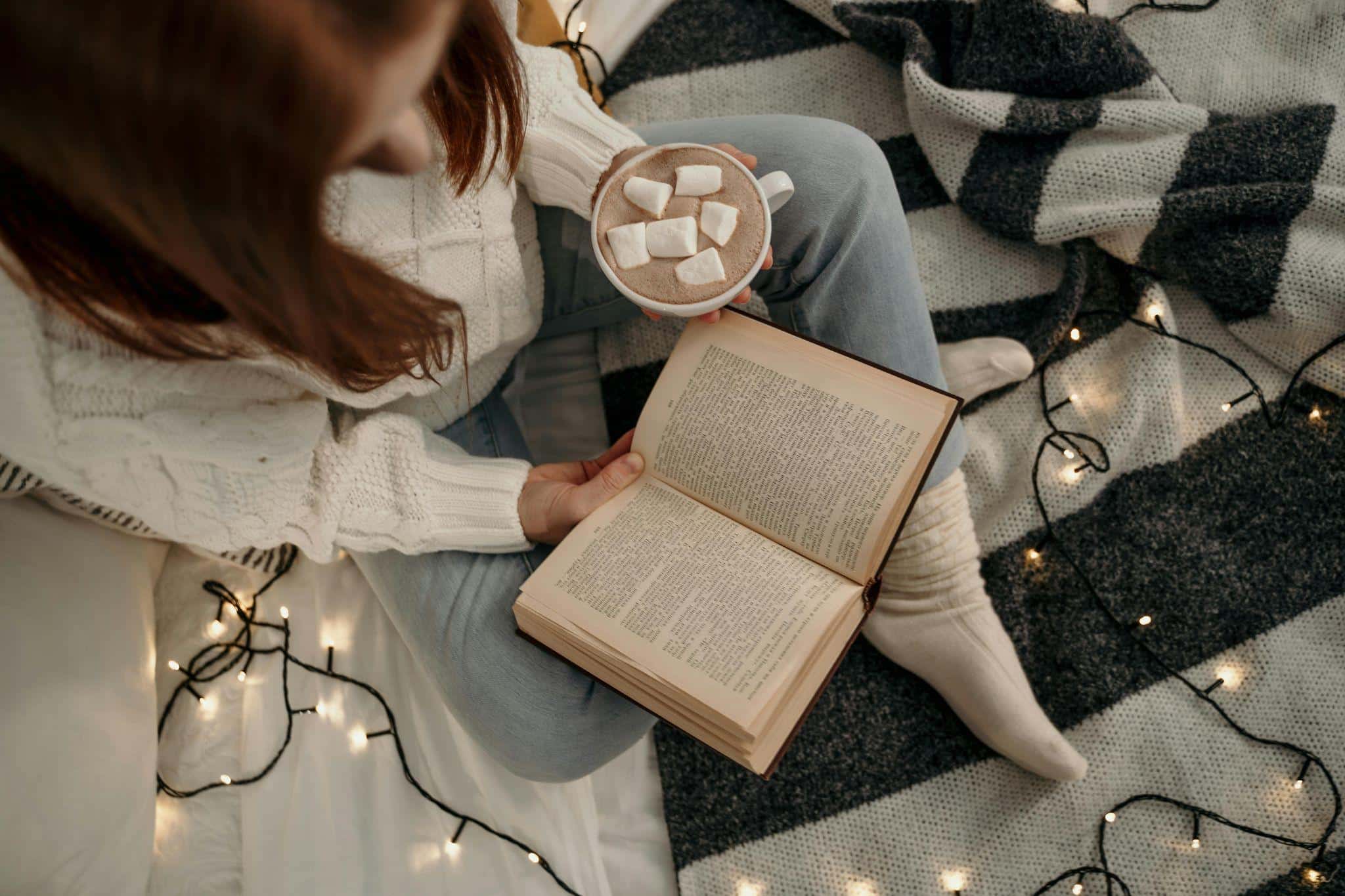 girl reading book on cozy bed